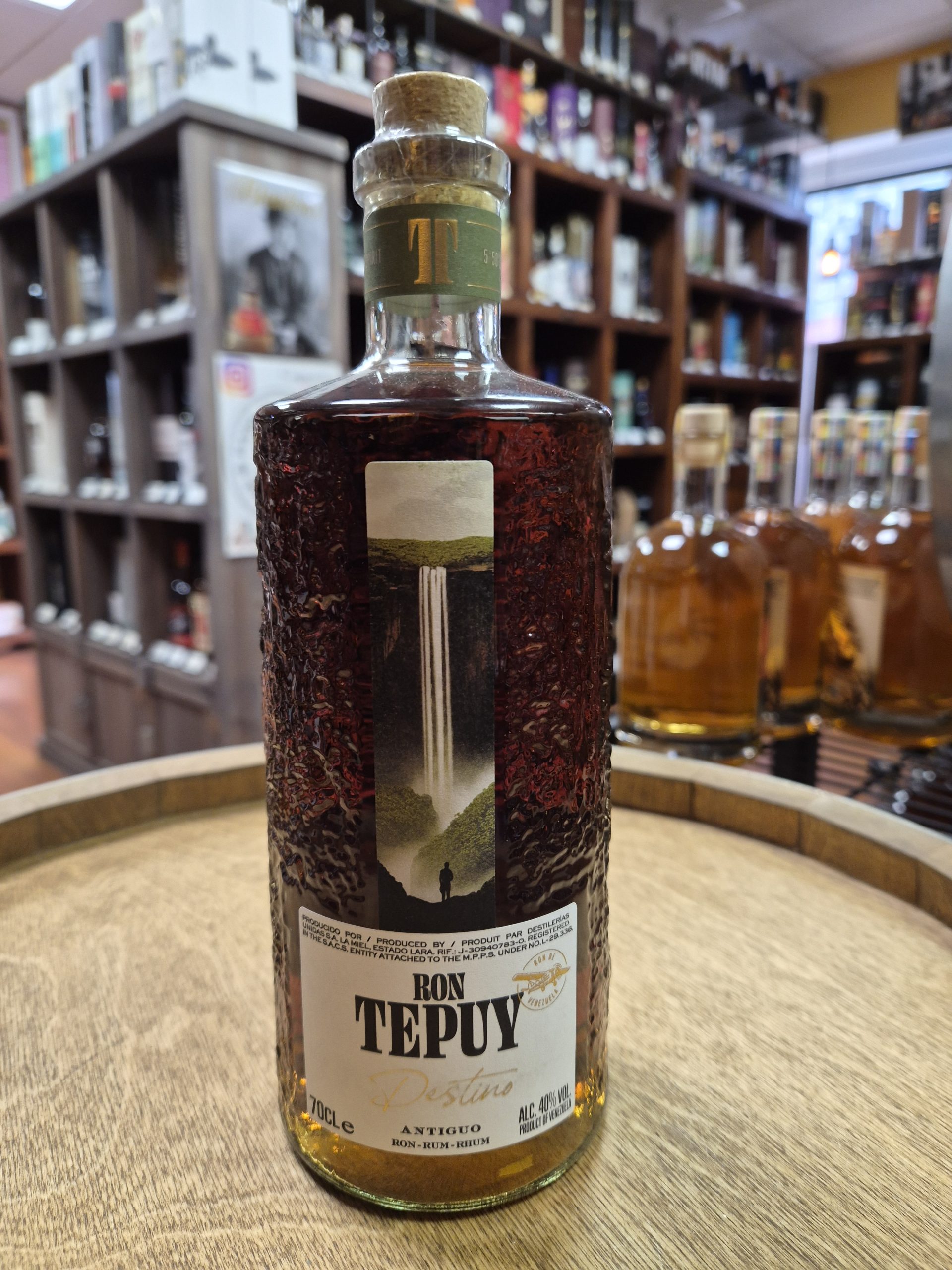 Ron Tepuy Destino – Rhum du Venezuela – 40% 2 Photographie de produit professionnelle de la bouteille Ron Tepuy Destino 70cl, 40% vol, sur un tonneau en bois. L'étiquette montre l'avion survolant un Tepuy, avec la mention 'Amontillado Sherry Oak Finish'